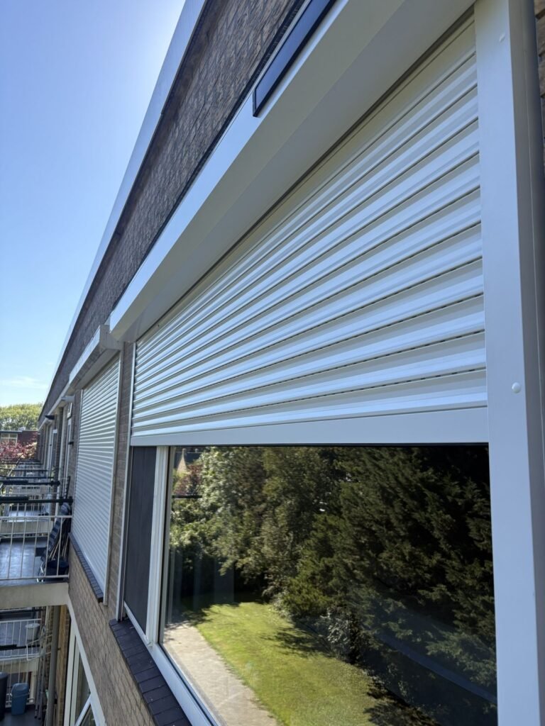 Wit rolluik met zonnepaneel op de kast, van dichtbij