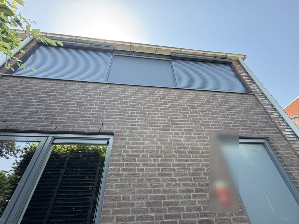 Rolluiken op de bovenverdieping van een bakstenen woning